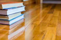 Image of Oak Wood Floor on which pile of hard backed books are placed