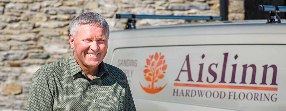 Image of company proprietor standing in front of Aislinn Hardwood Flooring van