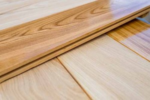 Over lapping planks of European oak wood flooring showing comparison of raw and finished boards