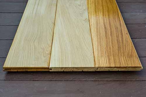 Oak wood floor boards showing contrast between raw and varnished wood flooring products