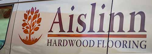 Side view of Aislinn Hardwood Flooring van bearing company name and logo